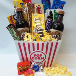 Popcorn bucket filled with candy bars and two soda bottles