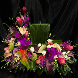 Tropical floral arrangement with purple orchids, anthuriums, and pink blooms