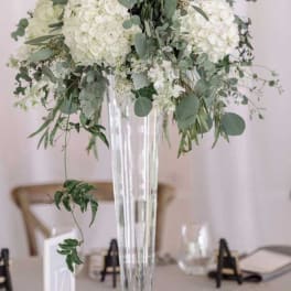 White floral centerpiece in a tall clear vase
