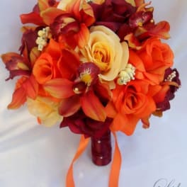 Orange and burgundy bouquet with roses and orchids, tied with ribbon