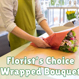 Florist wrapping a mixed bouquet in pink paper