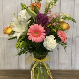 Mixed bouquet in a glass vase with a yellow ribbon