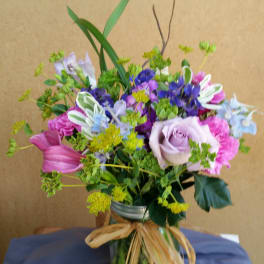 Mixed bouquet in a glass vase with pink, purple, and blue flowers
