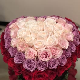 Heart-shaped bouquet of pink, purple, and red roses