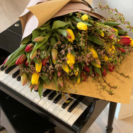 Bouquet of yellow and red tulips wrapped in brown paper