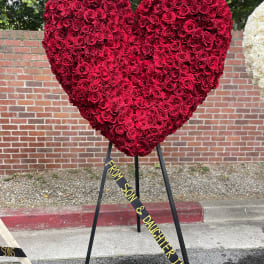 Large heart-shaped red rose arrangement on a stand