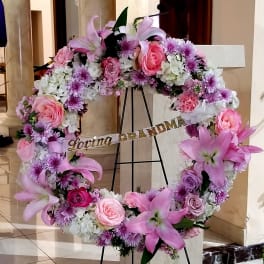 Pink and white floral wreath on an easel with a "Loving GRANDMA" ribbon