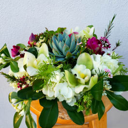Mixed bouquet with white orchids, lilies, and a blue succulent centerpiece
