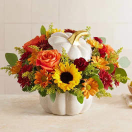 Autumn bouquet with a white pumpkin vase and mixed orange, yellow, and red flowers