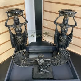 Decorative Egyptian-style statues with a winged bird sculpture in a display tray