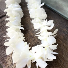 White flower garland laid on a wooden surface