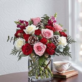 Bouquet of pink and white roses with red carnations in a glass vase