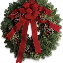 Christmas wreath with a red bow, pinecones, and berries