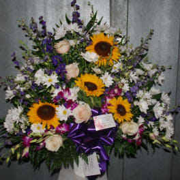 Large mixed flower spray with sunflowers, white daisies, and purple blooms