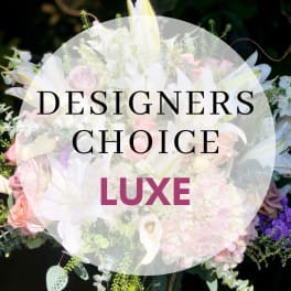 Mixed bouquet with lilies, roses, and hydrangeas under a "Designers Choice Luxe" label