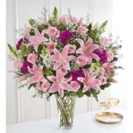 Pink lilies and roses in a clear glass vase
