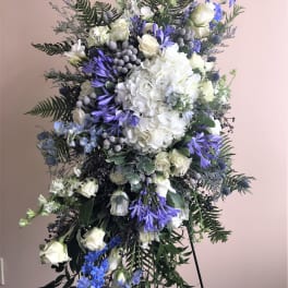 Tall white and blue floral standing spray with roses and hydrangea