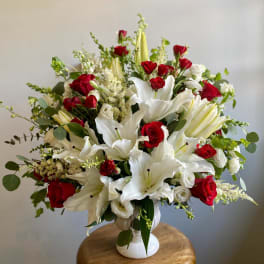 Red roses and white lilies in a white vase