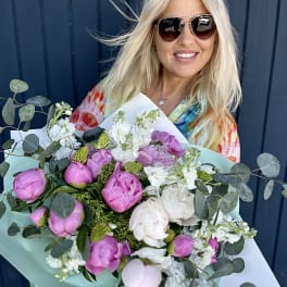 Bouquet of pink and white peonies with eucalyptus in pastel wrapping