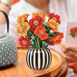 Arrangement of red and orange flowers in a striped vase