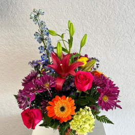 Mixed bouquet in a glass vase with lilies, roses, and daisies