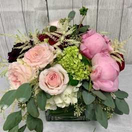 Pink and white roses with peonies in a glass vase