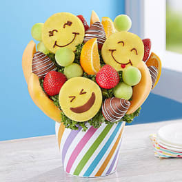 Fruit bouquet with smiley-face fruit pieces in a striped cup