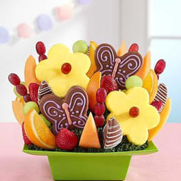 Fruit bouquet with chocolate-dipped strawberries and butterfly cookies in a green container
