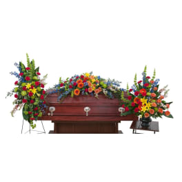 Casket with colorful funeral flower sprays and arrangements