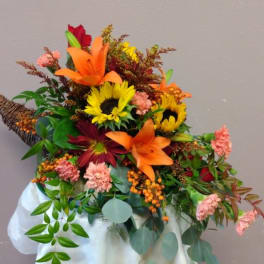 Autumn bouquet with sunflowers, lilies, and carnations in a white wrap