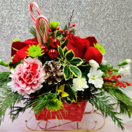 Holiday floral basket with red roses, pink carnation, and candy canes