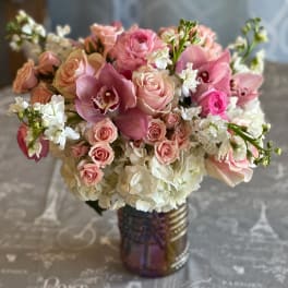 Pink roses and orchids arranged in a glass vase