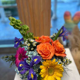 Mixed bouquet with orange roses, purple irises, and yellow gerbera daisies