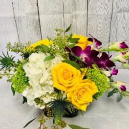 Bouquet of yellow roses, white hydrangeas, and purple orchids