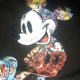 Black shirt with a large Mickey Mouse graphic and colorful character patches