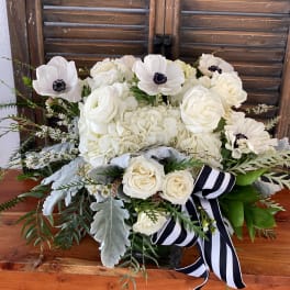 White floral bouquet with a black-and-white striped ribbon