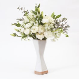 White floral arrangement in a tall white vase