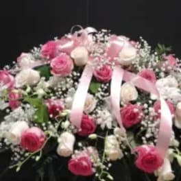 Pink and white rose arrangement with baby’s breath and ribbon