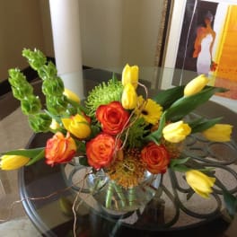 Bouquet of orange roses and yellow tulips in a glass vase