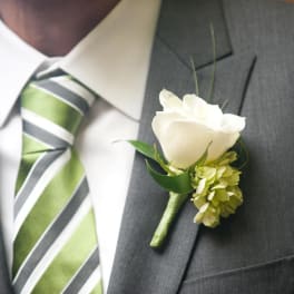 White rose boutonniere pinned to a gray suit jacket