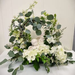 White floral wreath with eucalyptus and angel figurines