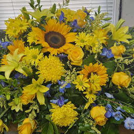 Yellow and blue mixed flower arrangement with sunflowers and roses