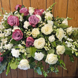 Casket spray with pink and white roses and mixed white flowers