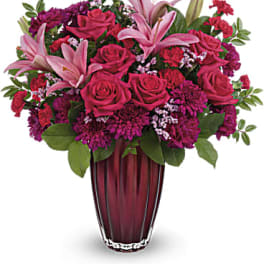 Pink lilies and roses in a burgundy vase