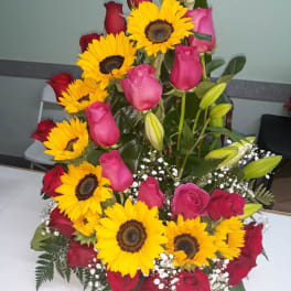 Bouquet of red and pink roses with yellow sunflowers and white baby's breath