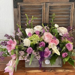 Mixed pink and white flower arrangement in a rustic wooden box