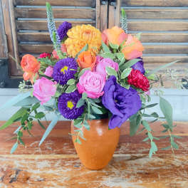 Colorful mixed bouquet in an orange vase