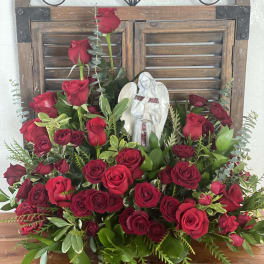 Large arrangement of red roses with an angel figurine