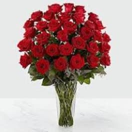 Large bouquet of red roses arranged in a clear glass vase