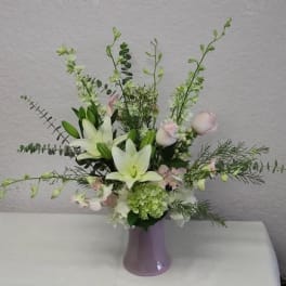 White lilies and pale pink flowers in a lavender vase